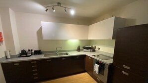 A modern kitchen with a central island, built-in oven, and a refrigerator.