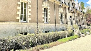 Ein großes, historisches Gebäude mit symmetrischer Architektur, zahlreichen Fenstern und einem gepflegten Garten.