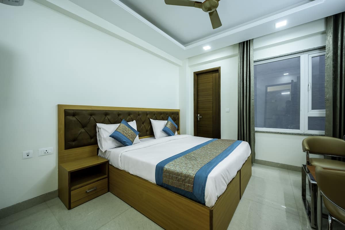 Un dormitorio con cama, mesita de noche y ventilador de techo.