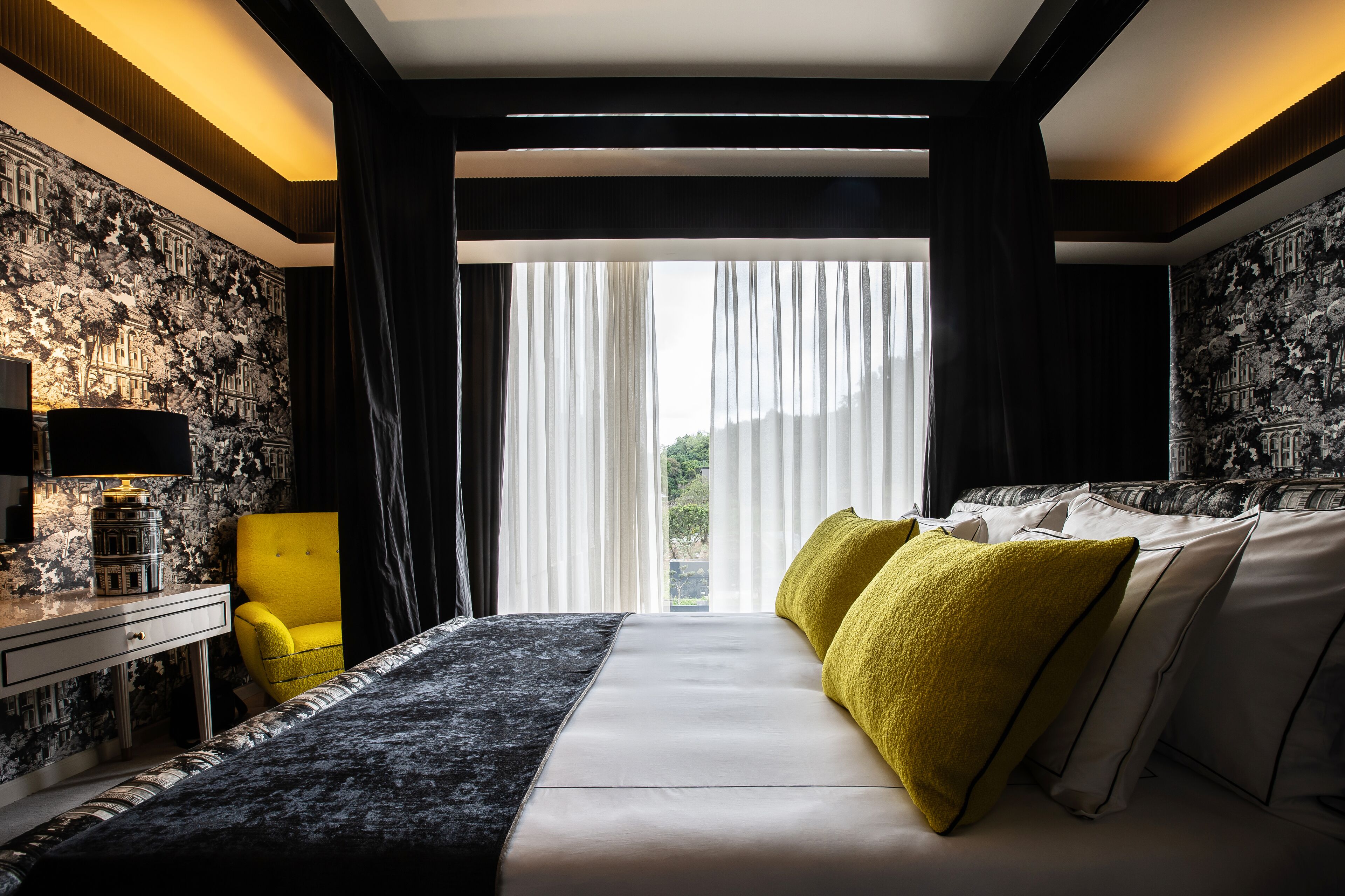 Una habitación de hotel moderna con una cama grande, un escritorio y una silla.