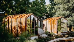 Two rustic wooden structures with large windows, surrounded by lush greenery and a small pond. - Vinha Boutique Hotel - The Leading Hotels of the World (Vila Nova de Gaia)