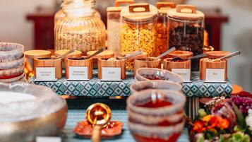 A buffet with labeled containers of various food items, including seeds and grains.