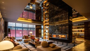 A spacious living area with a fireplace, comfortable seating, and a high ceiling with exposed beams.