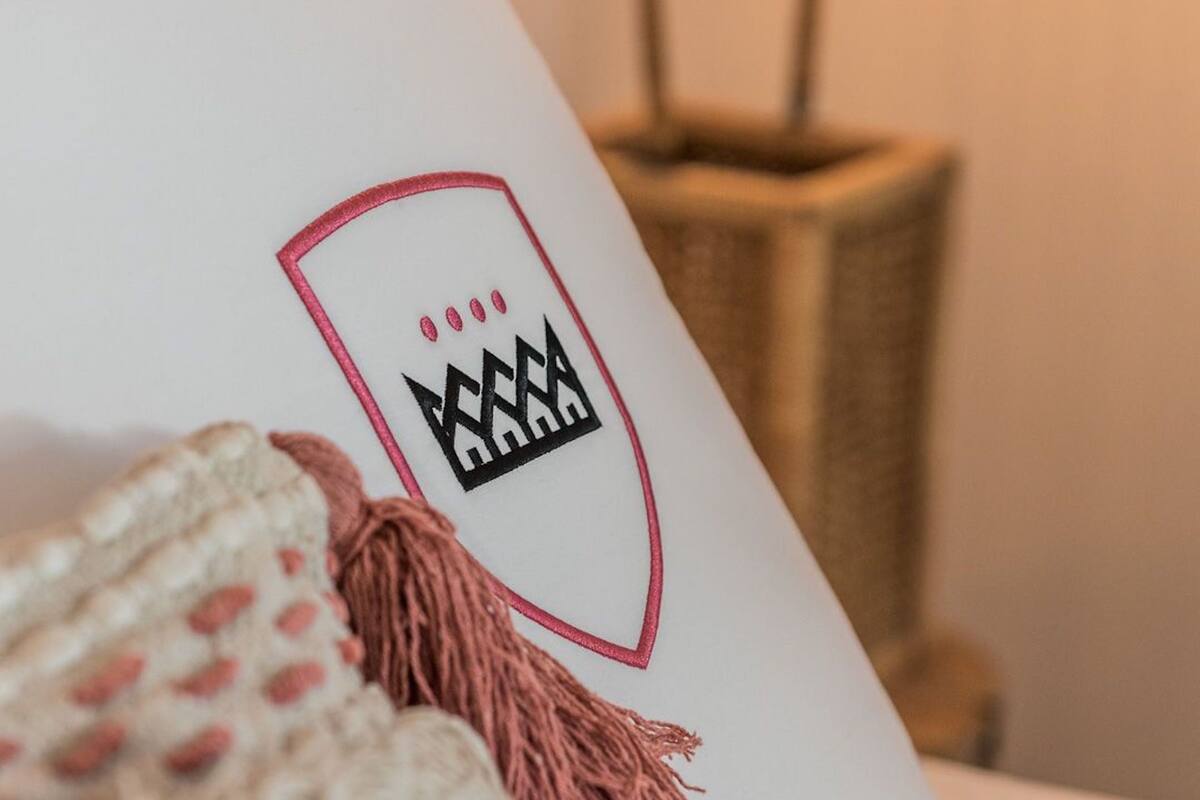 A white object with a logo and a pink tassel.