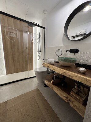A modern bathroom with a shower, toilet, and vanity.