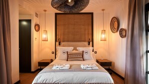 A hotel room with a large bed, two bedside tables, a wall-mounted lamp, and a ceiling light fixture. - Hotel Santo Cristo La Ciudadela Marbella (Marbella)
