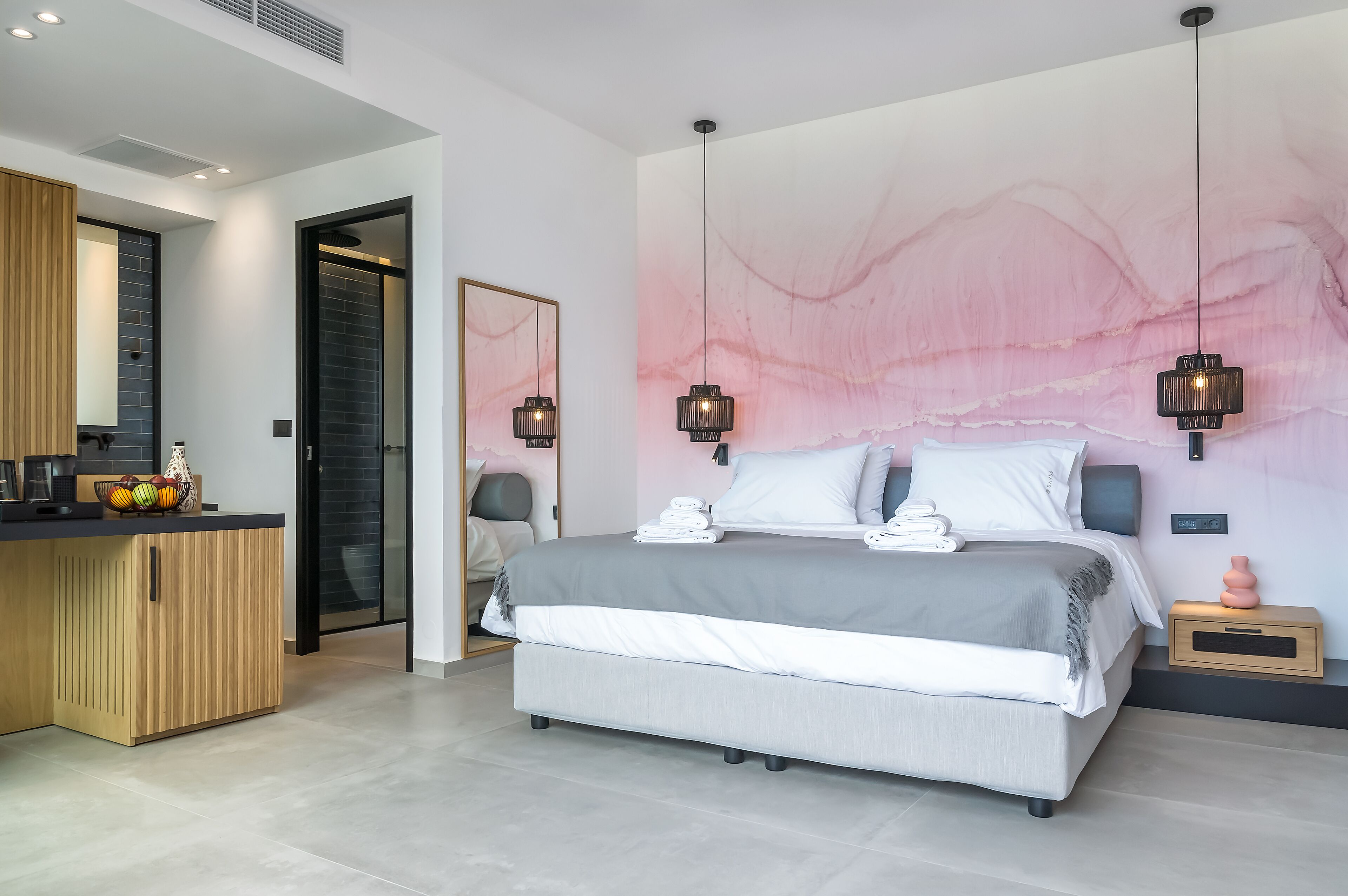 A modern bedroom with a large bed, bedside tables, and a wall-mounted artwork.