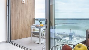 Un balcon moderne avec une porte vitrée donnant sur un espace repas.