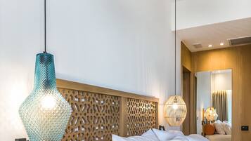 A modern hotel room with a wooden headboard, white bedding, and a telephone on a wooden side table.