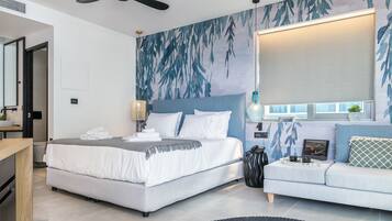 Un dormitorio moderno con cama, sofá, escritorio y un amplio ventanal.