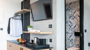 Une salle de bain moderne avec des carreaux décoratifs, des toilettes et un coin lavabo doté d’un miroir et d’un porte-serviettes.