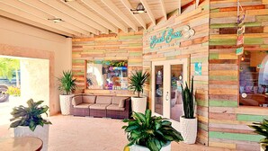 Ein gemütliches Café mit Holzfassade, einer Sitzecke mit einer Couch und Topfpflanzen.