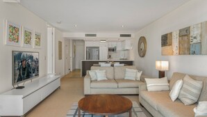 Ein modernes Wohnzimmer mit Sofa, Couchtisch und Kunstwerken an den Wänden.