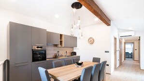 Una cocina moderna con armarios grises, una mesa de comedor de madera y sillas azules.
