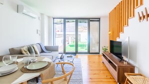 Een moderne woonkamer met een bank, een eettafel en een televisie.