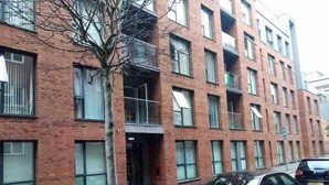 A multi-story brick building with a flat facade, several windows, and a tree in front. - Stylish 2-bed Apartment in Manchester City Center (Manchester)