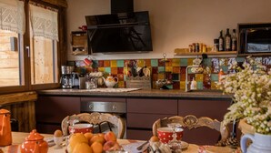 Una cocina acogedora con armarios de madera, un salpicadero de azulejos y un televisor sobre la encimera.