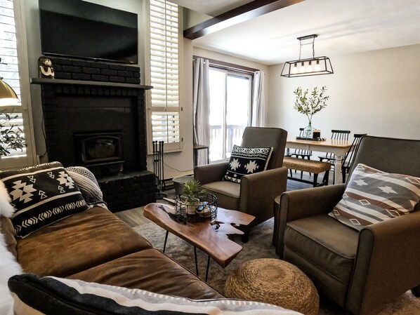 A cozy living room with a fireplace, comfortable seating, and a dining area. - Incredible View! Completely Remodeled! Heated Pool! 2 Miles to Purgatory! (Durango)