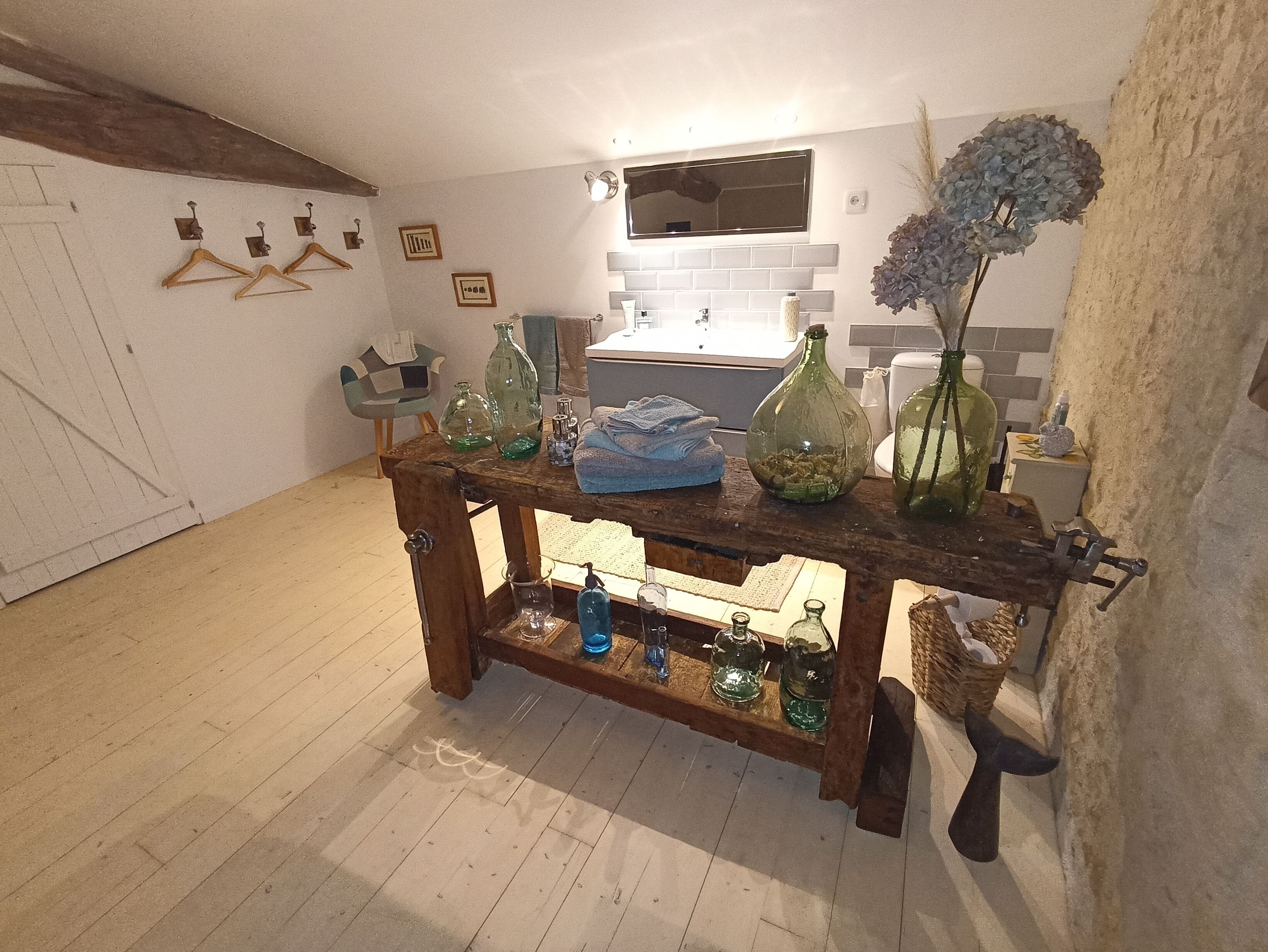 Une table en bois rustique, avec des bouteilles en verre et une serviette bleue.