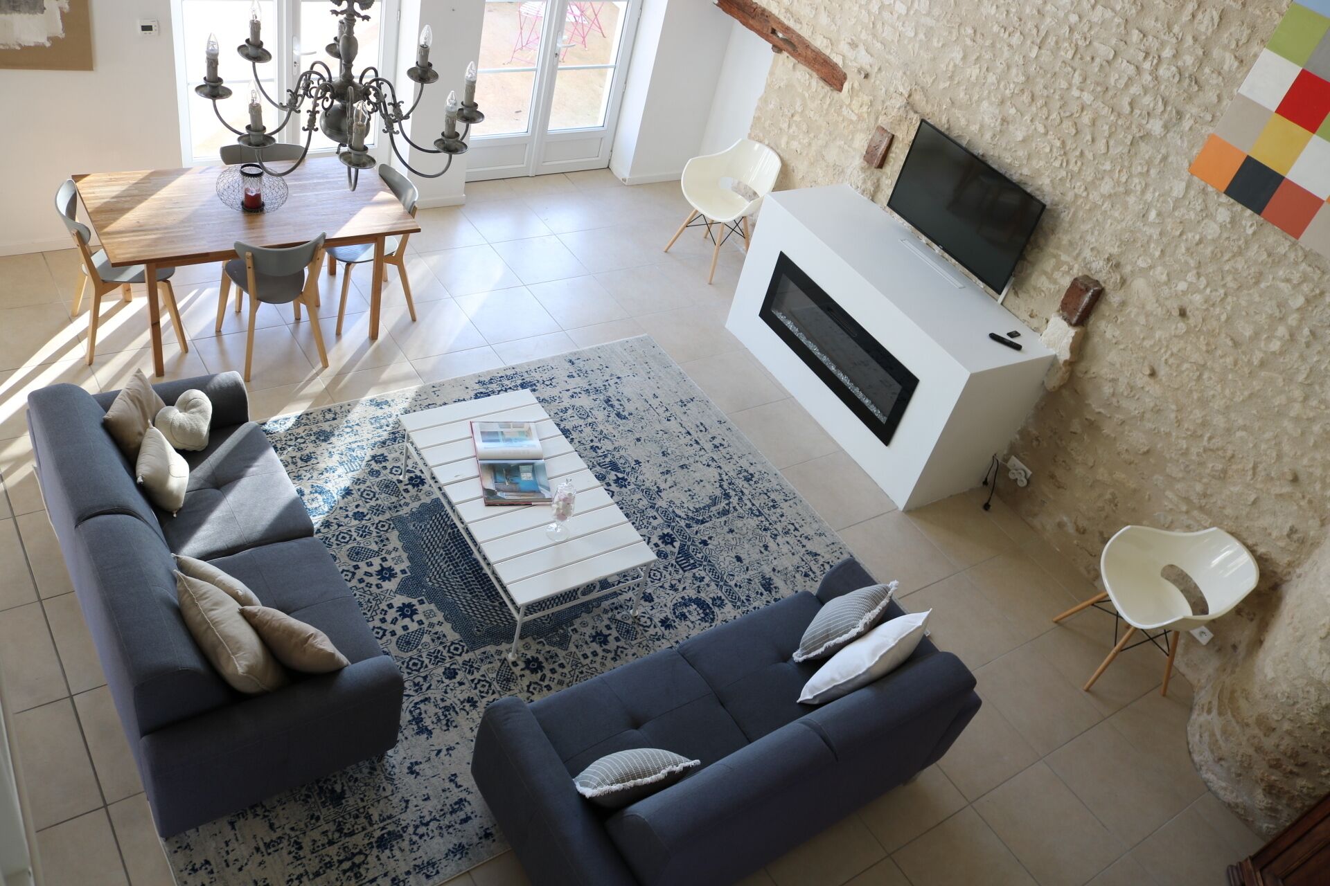 A modern living room with a sofa set, a coffee table, a fireplace, and a TV.