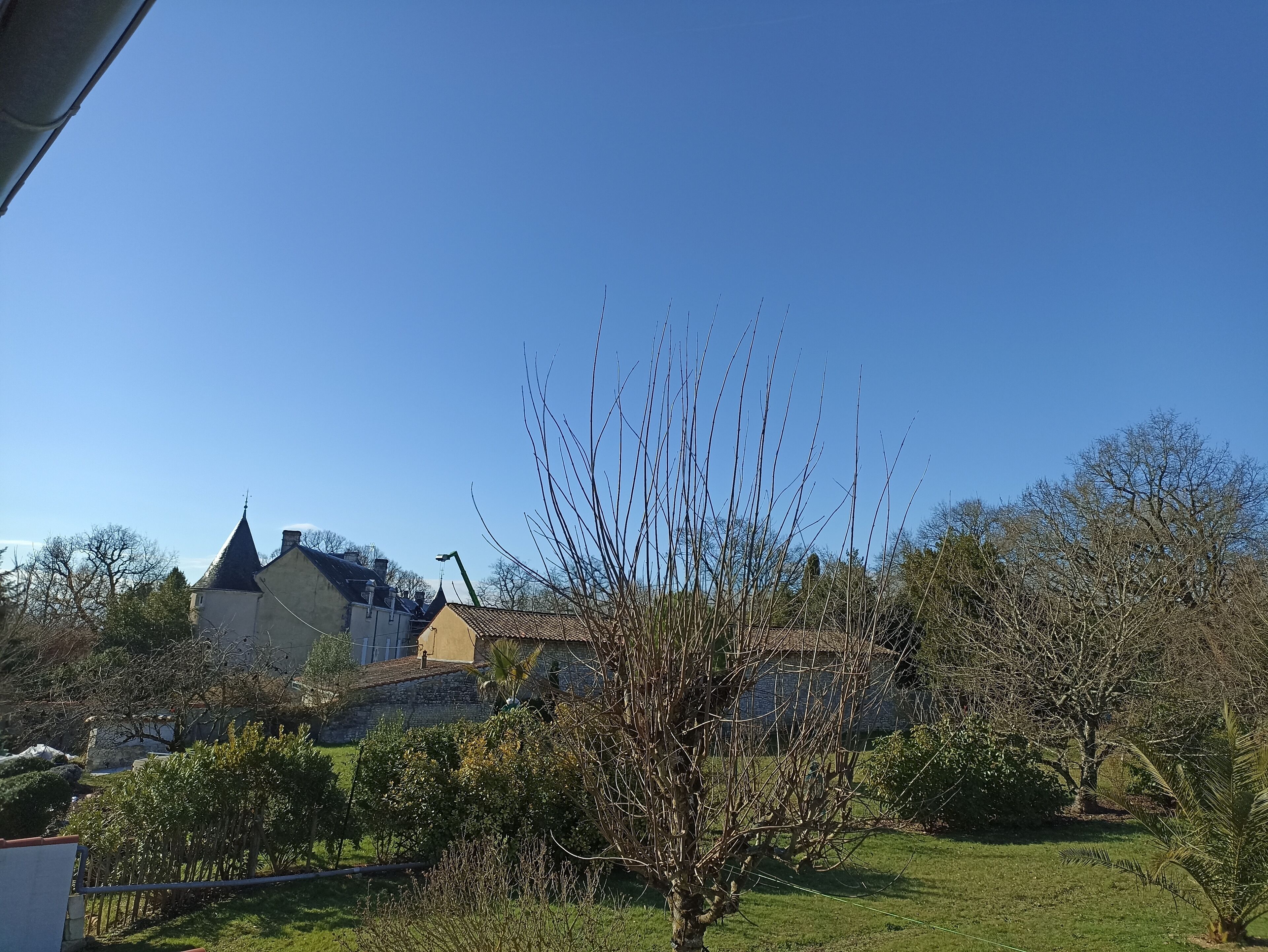 A residential area with a house featuring a prominent tower and a well-maintained lawn.