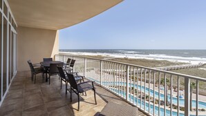 Ein Balkon mit Meerblick, ein Pool und Sitzgelegenheiten im Freien.