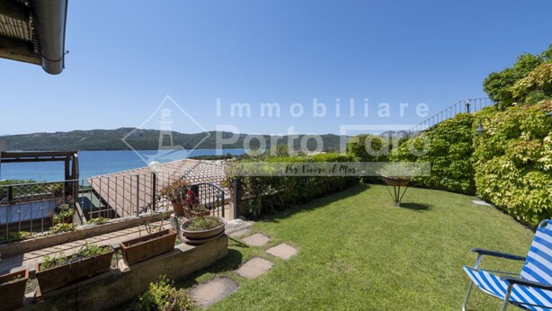Eine Terrasse mit Meerblick, ein Garten mit trittfesten Steinen und ein blauer Stuhl.