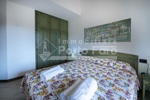 A bedroom with a bed, a green wardrobe, and a map on the wall. - 18BAIADELFARO - 18 BAIA DEL FARO (Palau)
