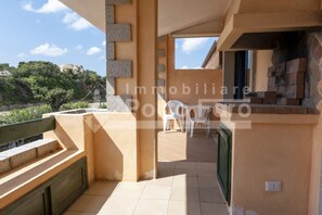 Un balcone con vista sul mare e un edificio con pavimento piastrellato.
