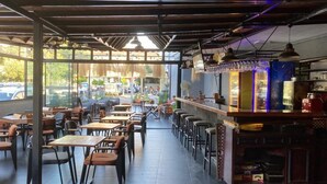A restaurant with outdoor seating, a bar area, and large windows offering views of the street. - The Pera Hotel Marmaris (Marmaris)