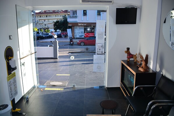 A hotel lobby with a reception desk, a TV, and a small seating area. - The Pera Hotel Marmaris (Marmaris)