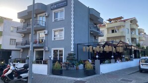 A hotel with a modern design, featuring balconies, a terrace with outdoor seating, and a sign indicating it is The Pera Hotel. - The Pera Hotel Marmaris (Marmaris)