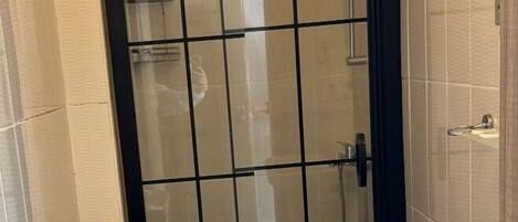 Un baño pequeño con inodoro, lavamanos y zona de ducha.
