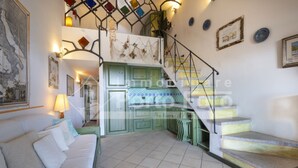 Ein großzügiger Wohnbereich mit einer grünen Wendeltreppe, einem Sofa und einer Küchenzeile.