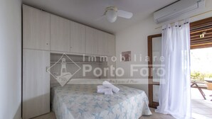 A bedroom with a bed, a ceiling fan, an air conditioning unit, and a view of the outdoors. - 7A Appartamento - 7A PORTO MANNU (Palau)