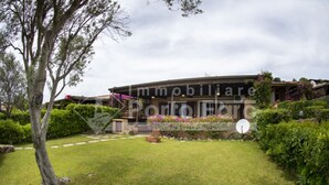 A property with a covered outdoor area, a well-maintained lawn, and a satellite dish. - 7A Appartamento - 7A PORTO MANNU (Palau)