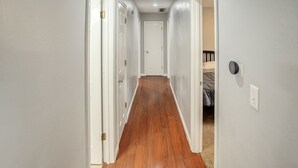 A narrow hallway with wooden flooring, white walls, and white doors. - Belleville Beauty - Luxury Stay For Work Or Stay For Play Either Way This Is The Perfect Property For You! 4 Bedroom Residence by RedAwning (Belleville)