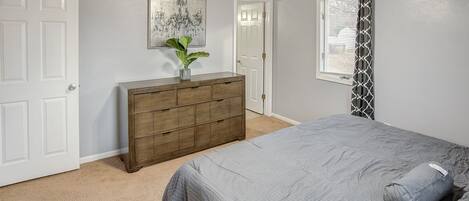 Ein Schlafzimmer mit Bett, Schminktisch und Deckenventilator.