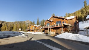 Une rangée de chalets en bois dotés de balcons, se dressant sur fond de montagnes enneigées.