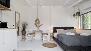 A bedroom with a bed, bedside table, and a window with blinds. - Little Beach House - Great couples getaway! (Zandvoort)