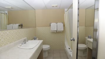 Bañera con ducha, toallas, jabón, shampoo