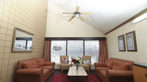A living room with two sofas, a coffee table, and a ceiling fan. - Owen Sound Inn (Owen Sound)