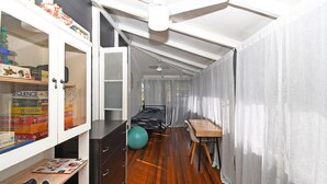 Une petite pièce comprenant un lit, un bureau et une étagère où sont rangés des jeux de société.