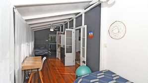 Une pièce compacte, à aire ouverte, comprenant un lit, une petite table et un coin cuisine.