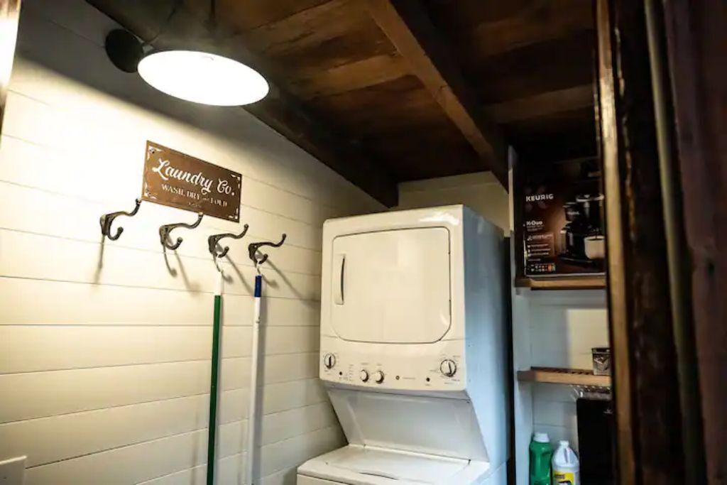 A laundry room with a washing machine, a drying machine, and a sign that reads "Laundry Co."