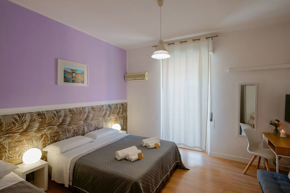 Une chambre à coucher comprenant un lit, des tables de chevet, un bureau et une chaise.