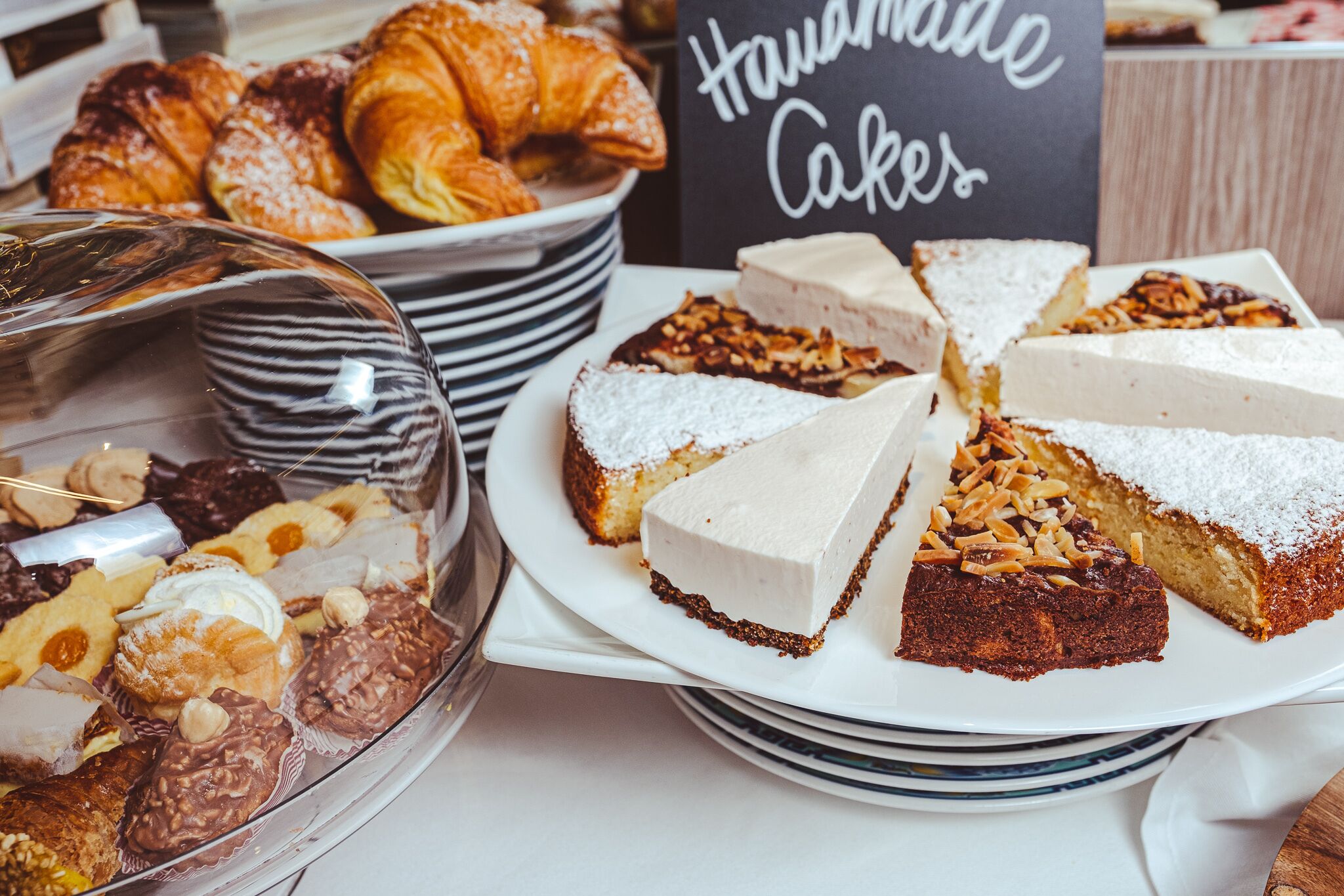 Une variété de desserts, notamment des gâteaux et des pâtisseries, sont disposés sur une table.