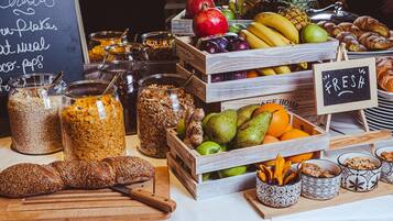 A breakfast buffet with various food items and a sign that says "FRESH".