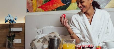Colazione servita su vassoio con caffettiera, succo di frutta e frutta fresca.