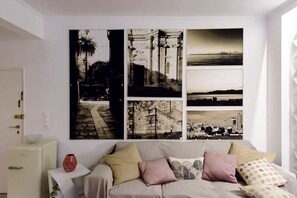 Ein Schlafzimmer mit einem Bett, einem Nachttisch und einem an der Wand hängenden Kunstwerk.